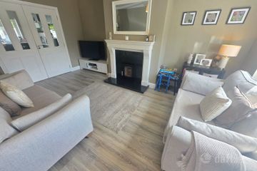 Spacious sitting room area with solid fuel stove and double doors to kitchen/dining room